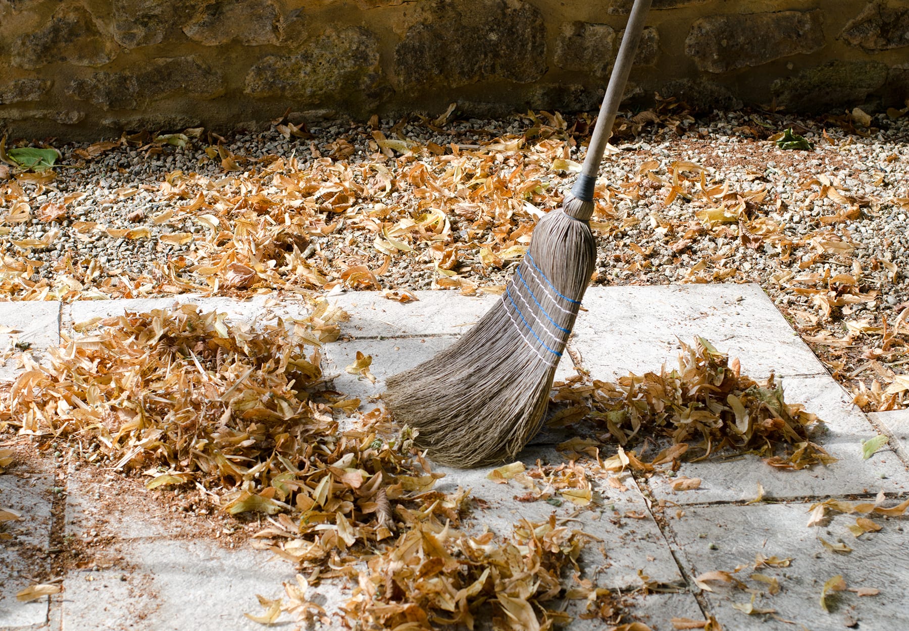 Pile of leaves with a broom being swept up
